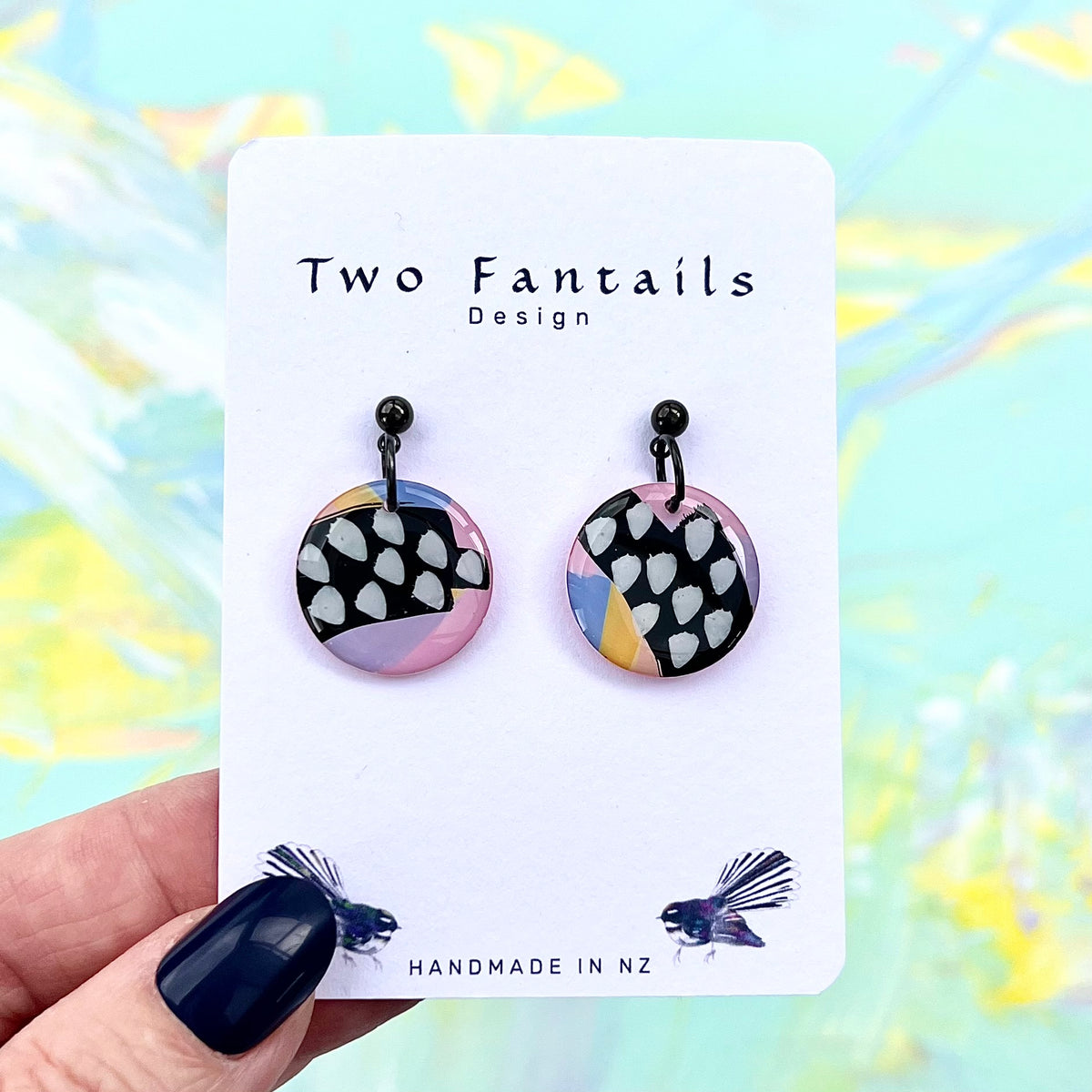 Black and white spotted round dangle earrings with pastel pink lilac blue and yellow abstract colour blocks