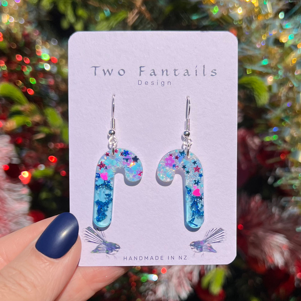 Pale blue candy cane drops filled with blue glitter and colourful stars