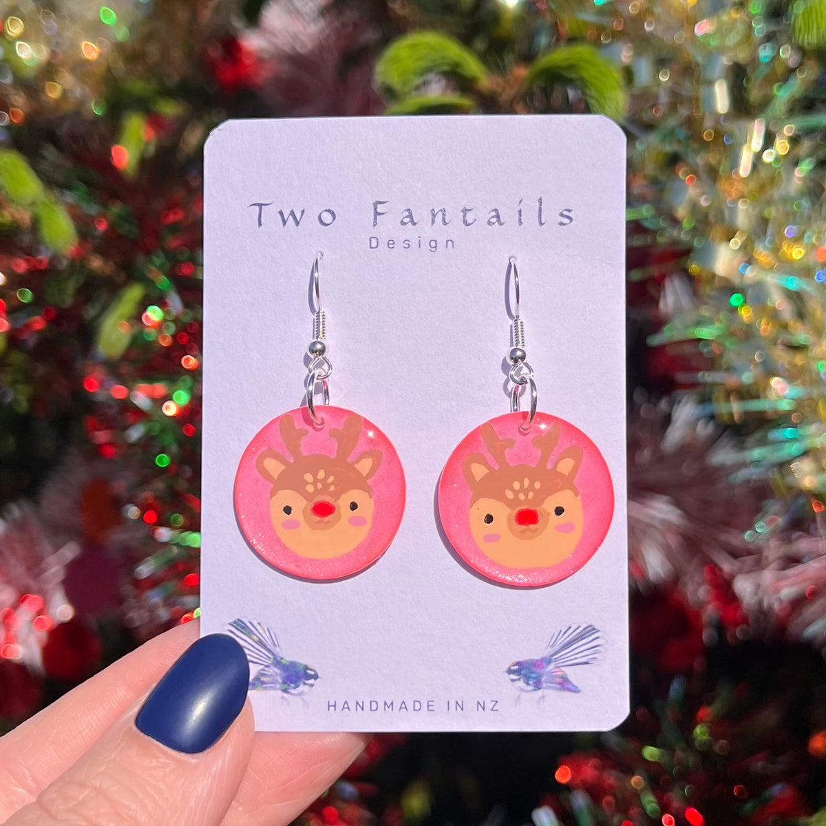 Pink round drops with cute reindeer faces and red noses