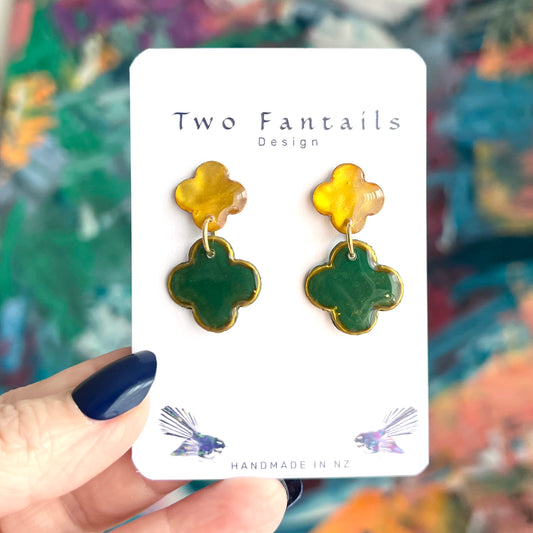 Handmade two-tier clover flower dangle earrings with glossy golden yellow stud tops, deep green drops and gold edging by Two Fantails Design