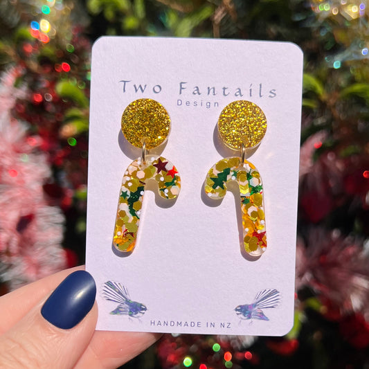 Golden glitter round studs paired with transparent candy canes packed with gold, white, red and green festive confetti