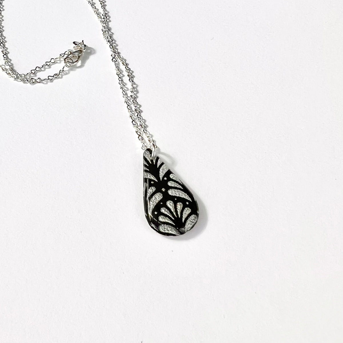 Close-up of black and silver Art Deco inspired teardrop pendant
