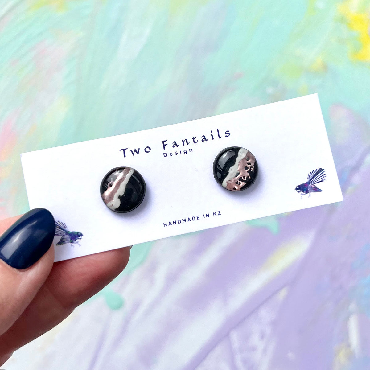 Glossy black round stud earrings with blush pink, cream and metallic rose accents