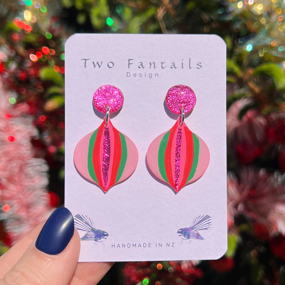 Pink Christmas baubles with red and green stripes, a shiny magenta centre and pink textured studs