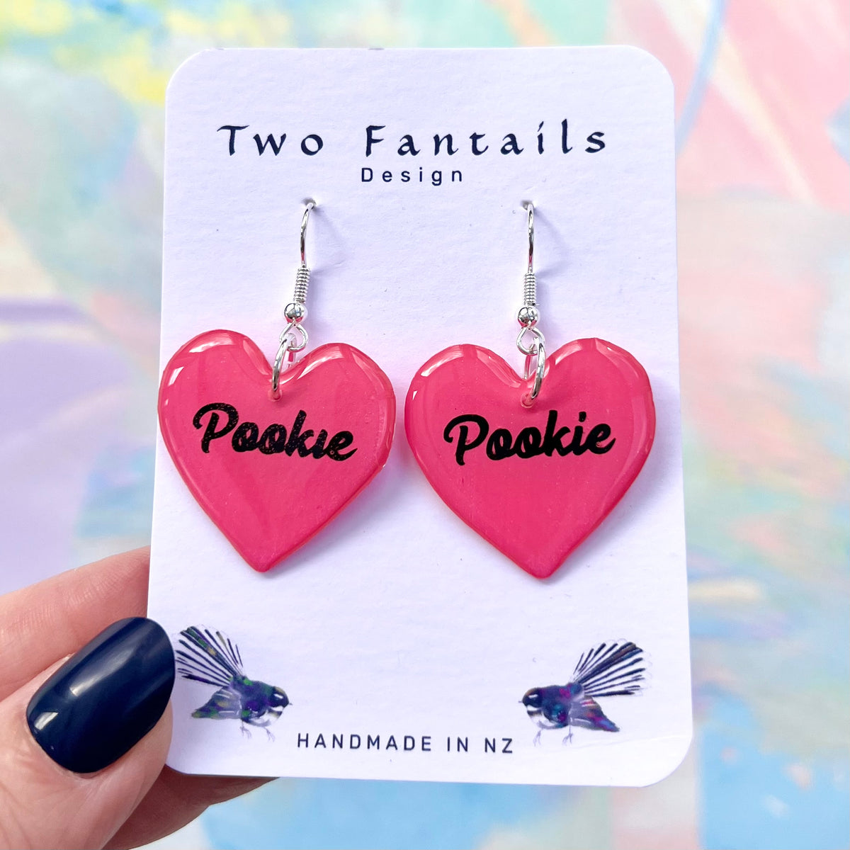 Bright pink heart earrings with black Pookie lettering and silver-tone hooks