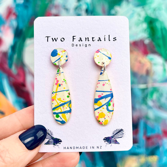 Splash Happy cream abstract long drop earrings with blue yellow pink and green paint splashes