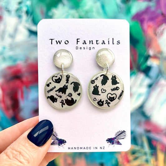 Meow Magic silver shimmer earrings with black cat doodles