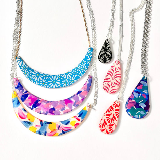 Colourful handmade statement necklaces with hand-painted floral and abstract pendants by Two Fantails Design